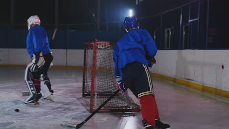 Ein-Hockeyspieler-Führt-Einen-Angriff-Auf-Das-Gegnerische-Tor-Durch.-Der-Im-Helm-Liegende-Spieler-Fängt-Den-Puck-Und-Rettet-Das-Spiel.-Eishockeyspieler,-Mann-Des-Spiels